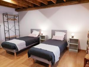 2 Betten in einem Zimmer mit Holzböden in der Unterkunft Gîte Saint-Poix, 5 pièces, 11 personnes - FR-1-600-212 