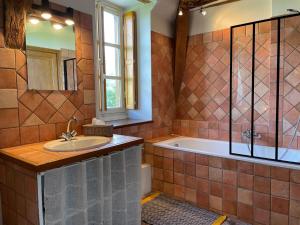 a bathroom with a tub and a sink at Maison de Famille près de Montargis - Élégance et Confort en Forêt - FR-1-590-354 in Paucourt