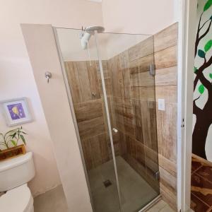 a shower with a glass door in a bathroom at Pousada - Aqui Hostel in Bragança Paulista