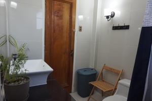 a bathroom with a sink and a toilet and a wooden door at Casa CasCal in Santiago