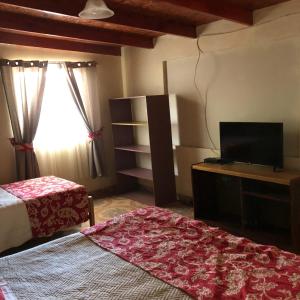 a bedroom with a bed and a flat screen tv at Cabañas el Chañar in San Pedro de Atacama