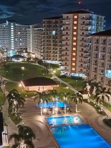 a view of a resort with two pools at night at Stunning 1-Bedroom Condo in Manila