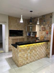 - une cuisine avec un comptoir en briques dans une pièce dans l'établissement Pousada Ferreira 415, à São Gabriel