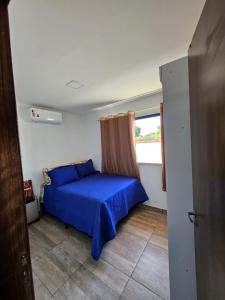 een slaapkamer met een blauw bed en een raam bij Residencial paraíso Pasárgada in Vera Cruz de Itaparica