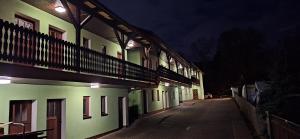 an empty street at night with green and white buildings at Sharma's Hotel in Ilmenau