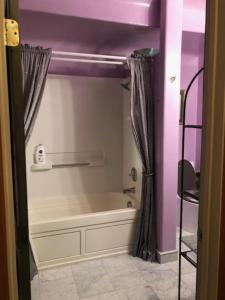 ein Badezimmer mit einer Badewanne und einer violetten Decke in der Unterkunft Margaret's Penthouse at Cannery Row and Aquarium in Monterey