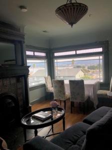 a living room with a table and two windows at Margaret's Penthouse at Cannery Row and Aquarium in Monterey