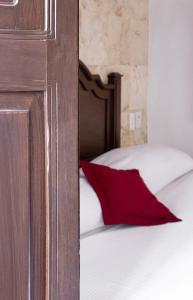 ein rotes Kissen auf dem Bett in der Unterkunft La Aurora Hotel Colonial in Valladolid