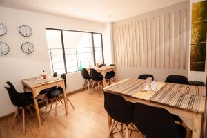 a room with tables and chairs and a clock on the wall at Hotel Primitivo Usaquén in Bogotá