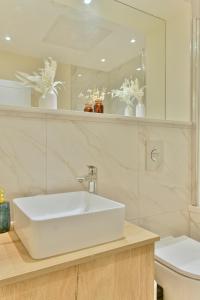 y baño con lavabo blanco y espejo. en Stunning apartment near citycentre & Oracle, en Reading