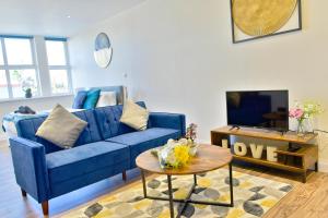 un soggiorno con divano blu e tavolo di Stunning apartment near citycentre & Oracle a Reading