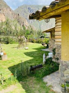 una casa con un patio con un campo de hierba en Cabaña del viajero., en Ollantaytambo