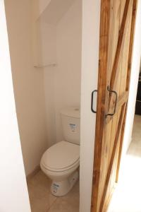 W pokoju znajduje się łazienka z białą toaletą. w obiekcie Casa Esther La Plata 1538 w mieście Melchor Romero