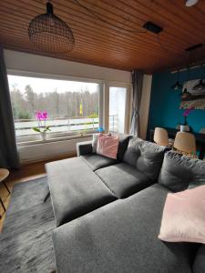 a living room with a couch and a large window at Haus am ruhige Lage in Langscheid Nähe sorpesee in Melschede