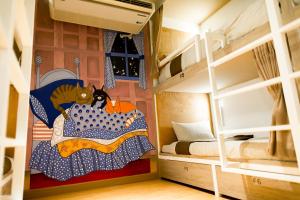 Zimmer mit Etagenbetten und einem Gemälde einer Katze im Bett in der Unterkunft Chiangmai Midpoint Activity Hostel in Chiang Mai
