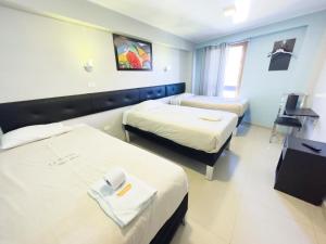 um quarto de hotel com duas camas e uma televisão em Quechuas Peru Hotel em Cusco