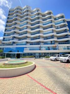 un gran edificio con coches estacionados frente a él en Apartamento beira mar Salvador Bahia, en Salvador