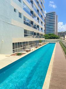 una piscina frente a un edificio en Apartamento beira mar Salvador Bahia, en Salvador