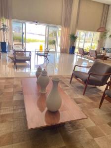 dos jarrones sentados en una mesa en una sala de estar en Apartamento beira mar Salvador Bahia, en Salvador