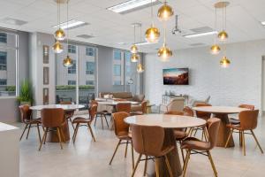 uma sala de jantar com mesas, cadeiras e janelas em The Stay At Brickell Club em Miami