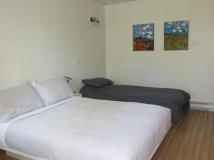 a bedroom with two beds and two paintings on the wall at Auberge Île du Repos in Honfleur