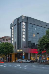 广州Paco Hotel Tianpingjia Metro Guangzhou - Free Shuttle Bus For Canton Fair的一座大楼，前面停满了汽车