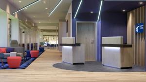 a lobby with a waiting area with tables and chairs at Holiday Inn Express Porto - Boavista, an IHG Hotel in Porto