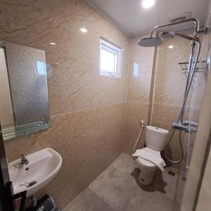 een badkamer met een toilet, een wastafel en een douche bij TRAVELBIZ HOTEL in Medan