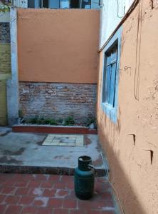a green trash can sitting next to a building at Seción de departamento en renta in La Armonía