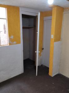 an empty room with yellow walls and an open door at Seción de departamento en renta in La Armonía