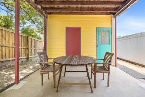 a table and chairs in front of a yellow house at Heart of Peregian in Peregian Beach