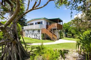 a house with a balcony and a yard at Heart of Peregian in Peregian Beach