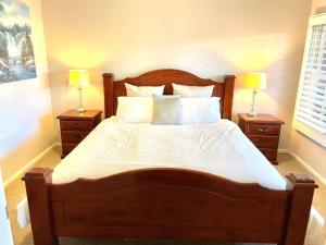 um quarto com uma grande cama de madeira e 2 mesas de cabeceira em Red hill cottage em Kingston 