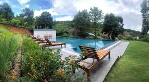 a row of benches sitting next to a swimming pool at Bungalow BIỂN ĐỒI in Phu Quoc