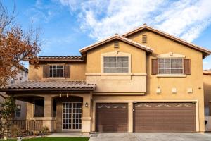 a house with a garage in front of it at 5BR 3BA Family friendly entire home w pool, spa, games, tvs, and more in Las Vegas