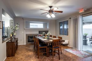 a dining room with a table and a ceiling fan at 5BR 3BA Family friendly entire home w pool, spa, games, tvs, and more in Las Vegas