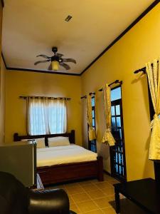 1 dormitorio con 1 cama y ventilador de techo en KEMBARA RESORT, en Setiu