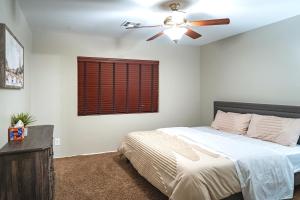 a bedroom with a bed and a ceiling fan at 5BR 3BA Family friendly entire home w pool, spa, games, tvs, and more in Las Vegas