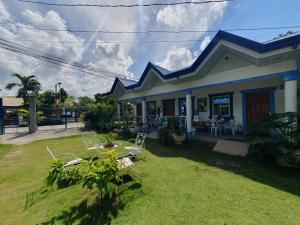 una casa con tavolo e sedie in cortile di Jah’s Anemone Dive Guesthouse a Moalboal