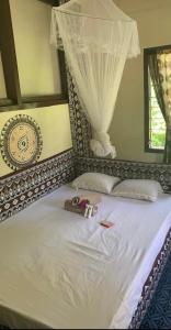 a bedroom with a white bed with a canopy at Wai Makare Homestay in Naviti Island