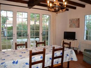 comedor con mesa, sillas y ventanas en Maison La Tranche-sur-Mer, 4 pièces, 6 personnes - FR-1-22-235, en La Tranche-sur-Mer