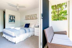 um quarto com uma cama e uma cadeira em Secret Gem em Peregian Beach