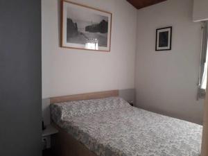 een slaapkamer met een bed en een foto aan de muur bij Maison La Faute-sur-Mer, 3 pièces, 4 personnes - FR-1-476-58 in La Faute-sur-Mer