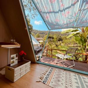 Zimmer mit einem Balkon mit einem Stuhl und einem Tisch in der Unterkunft An Suối Garden Tri Tôn An Giang 