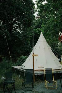 ein großes weißes Zelt mit 2 Stühlen und Bäumen in der Unterkunft An Suối Garden Tri Tôn An Giang 