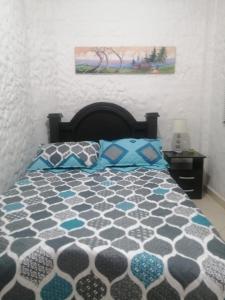 1 dormitorio con 1 cama y una foto en la pared en Apartamento Rionegro cerca al Aeropuerto, en Rionegro