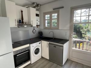 eine Küche mit einer Waschmaschine und einer Waschmaschine in der Unterkunft Maison Arcachon, 3 pièces, 5 personnes - FR-1-319-383 in Arcachon