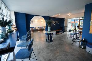 a lobby with blue walls and chairs and a table at KRAAM Silhouette Hotel & Cafe Phuket in Ban Kata