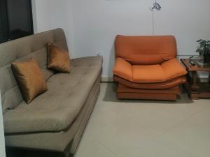 sala de estar con sofá y silla naranja en Apartamento Rionegro cerca al Aeropuerto, en Rionegro