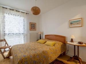 a bedroom with a bed with yellow pillows and a window at Appartement Arcachon, 5 pièces, 8 personnes - FR-1-319-404 in Arcachon